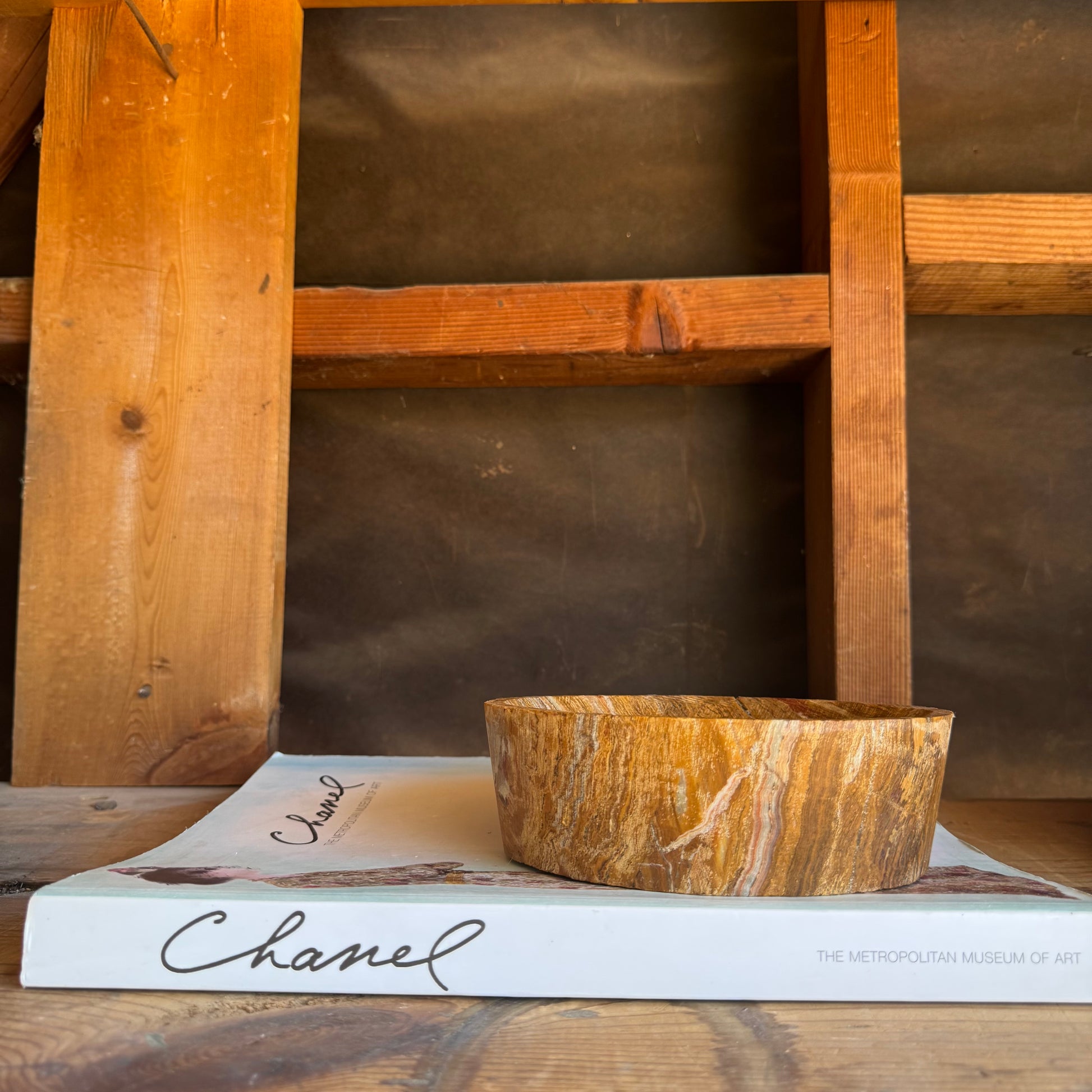 Golden ochre and sandstone onyx catchall bowl displayed on a gray surface, highlighting warm natural veining