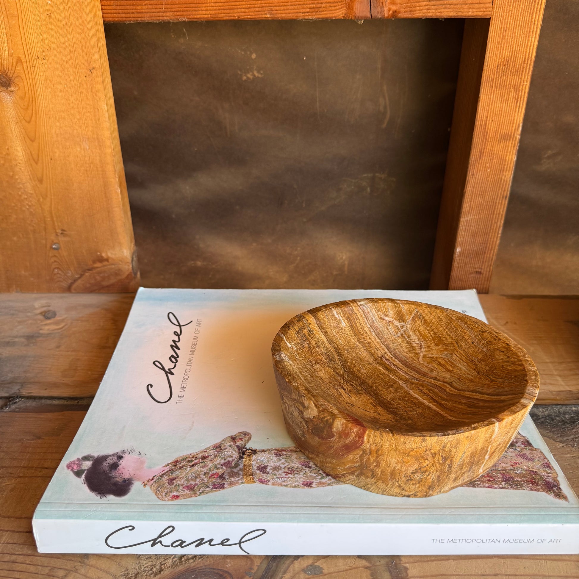 Golden onyx bowl styled as a bedside or altar vessel on a soft neutral background