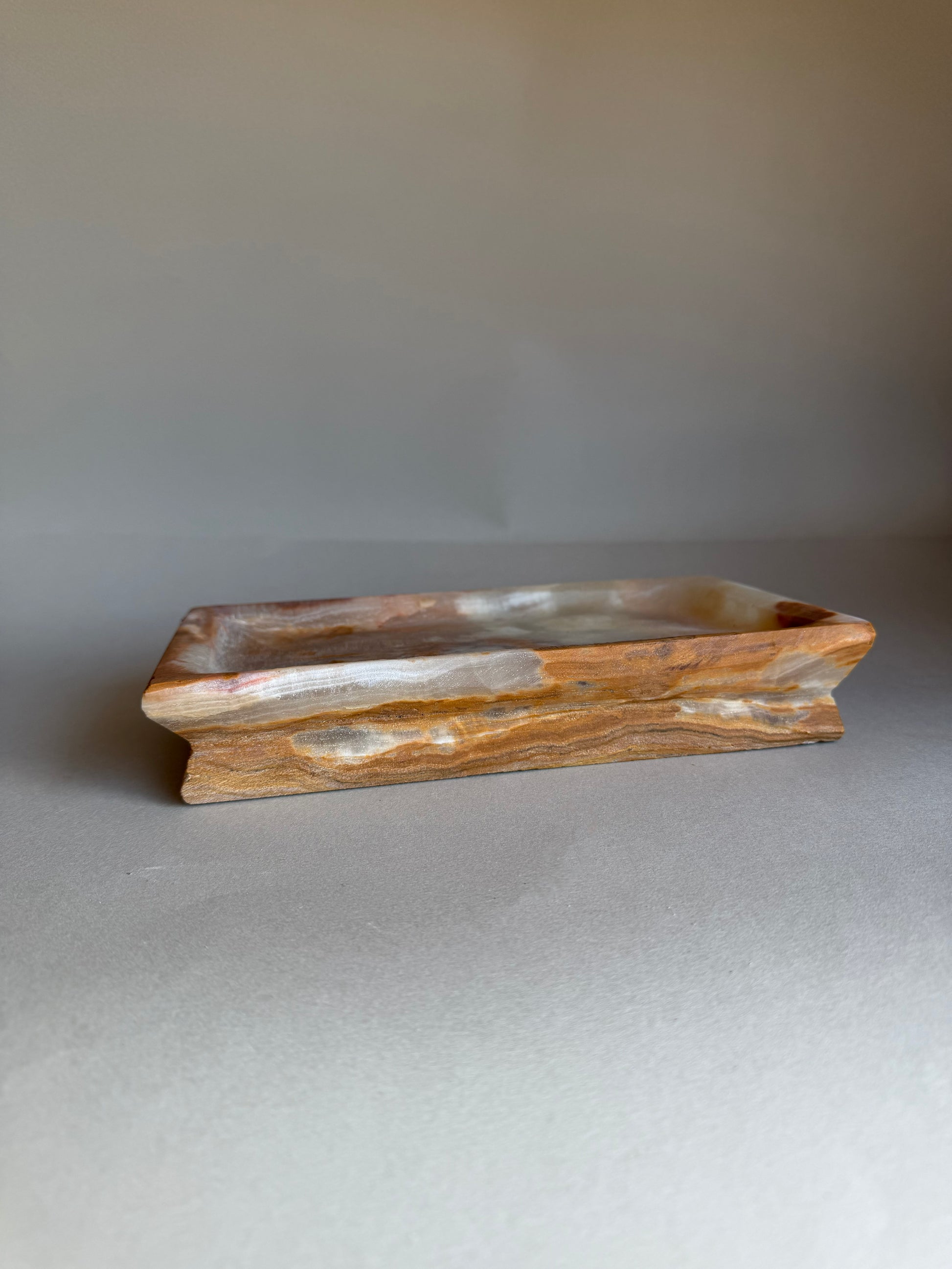 Wooden tray with wavy edge on a gray background