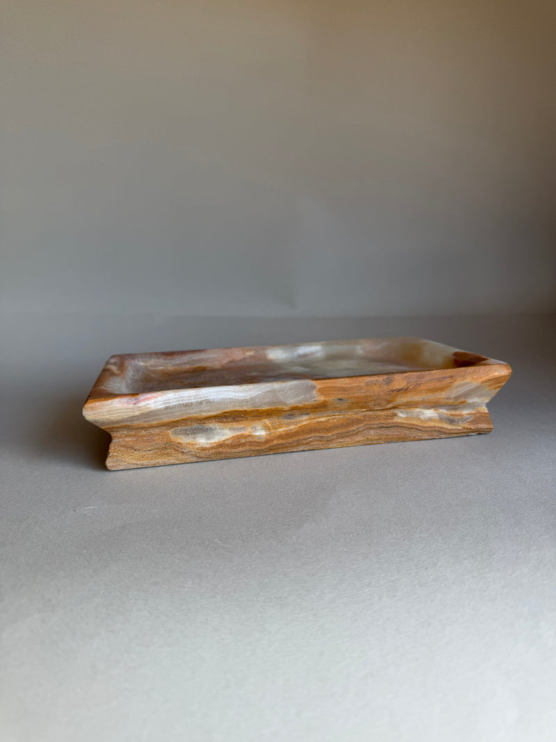 Wooden tray with wavy edge on a gray background