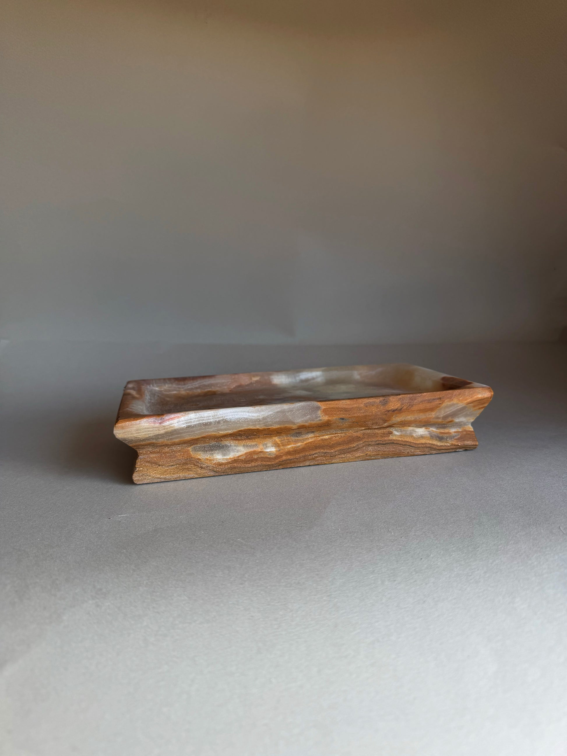 Wooden tray with a wavy edge on a gray background