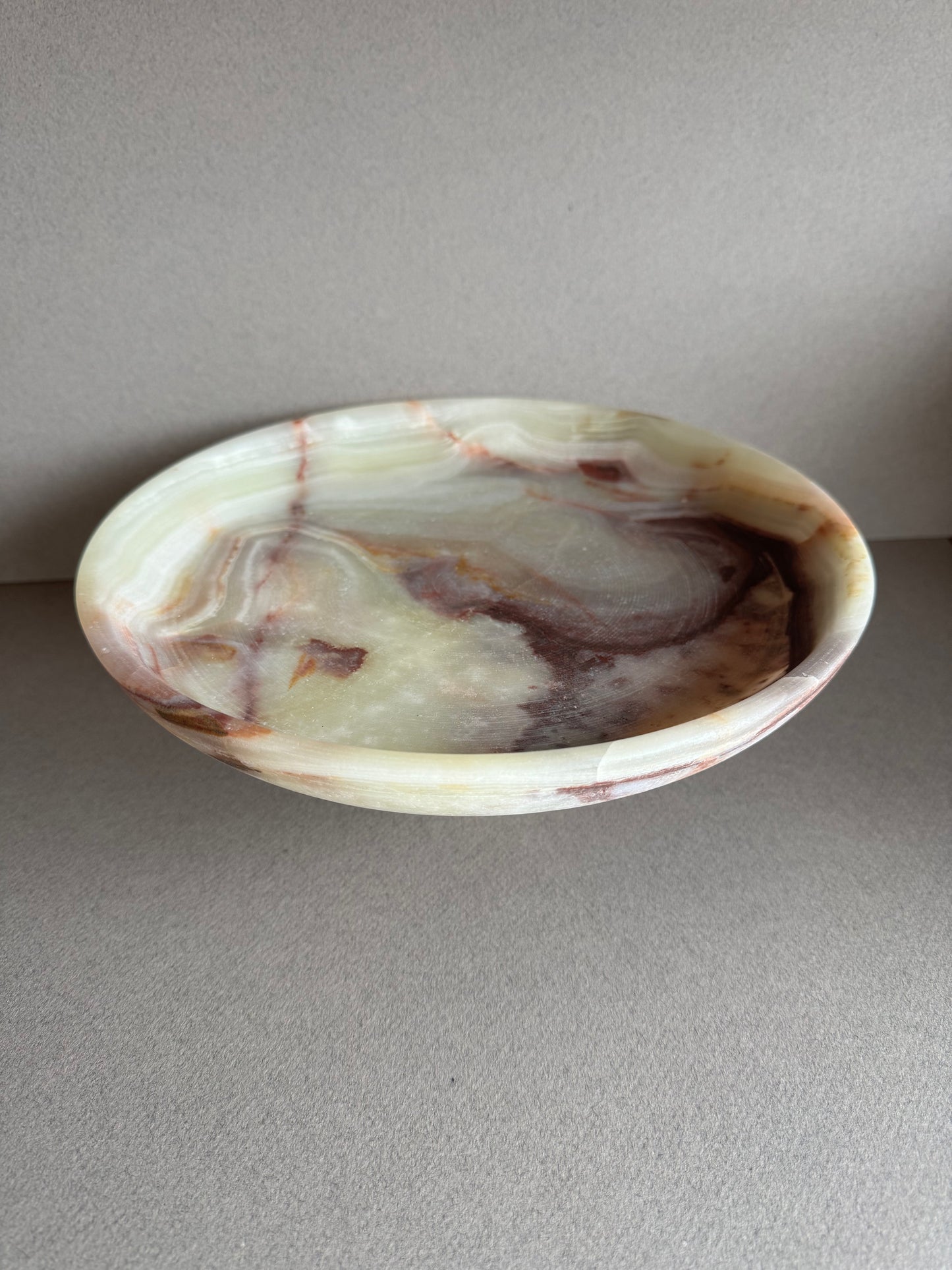 Close-up of natural onyx veining in warm cream, rust, and amber tones, highlighting the stone’s texture and detail