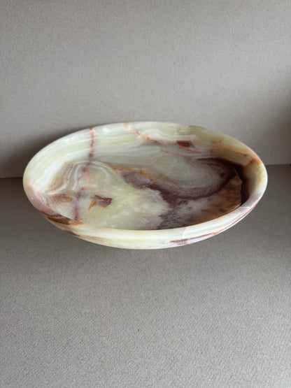 Close-up of natural onyx veining in warm cream, rust, and amber tones, highlighting the stone’s texture and detail