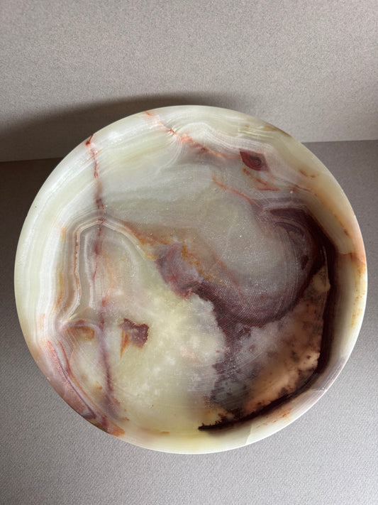 Close-up of natural onyx veining in warm cream, rust, and amber tones, highlighting the stone’s texture and detail