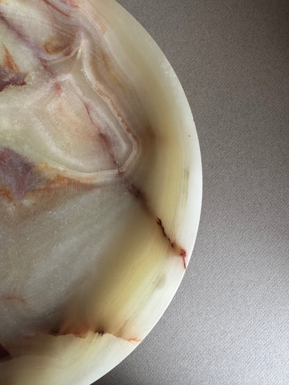 Close-up of natural onyx veining in warm cream, rust, and amber tones, highlighting the stone’s texture and detail