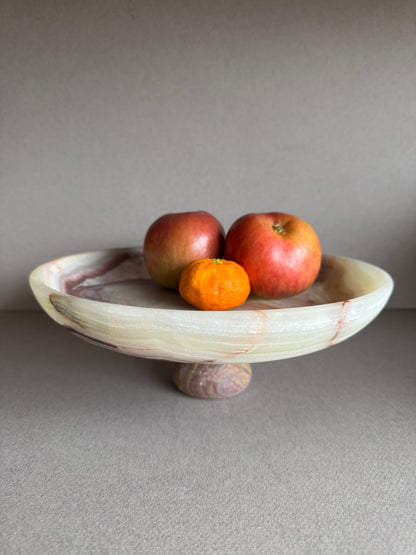 Sculptural onyx bowl used as a fruit bowl with natural elements in a minimalist living space