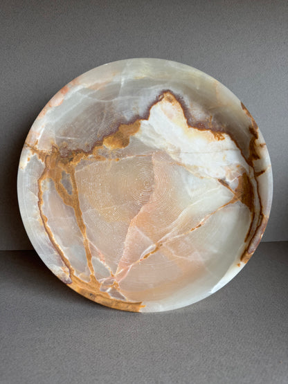 Side profile of ash-toned pedestal bowl with gentle veining and smooth carved form

