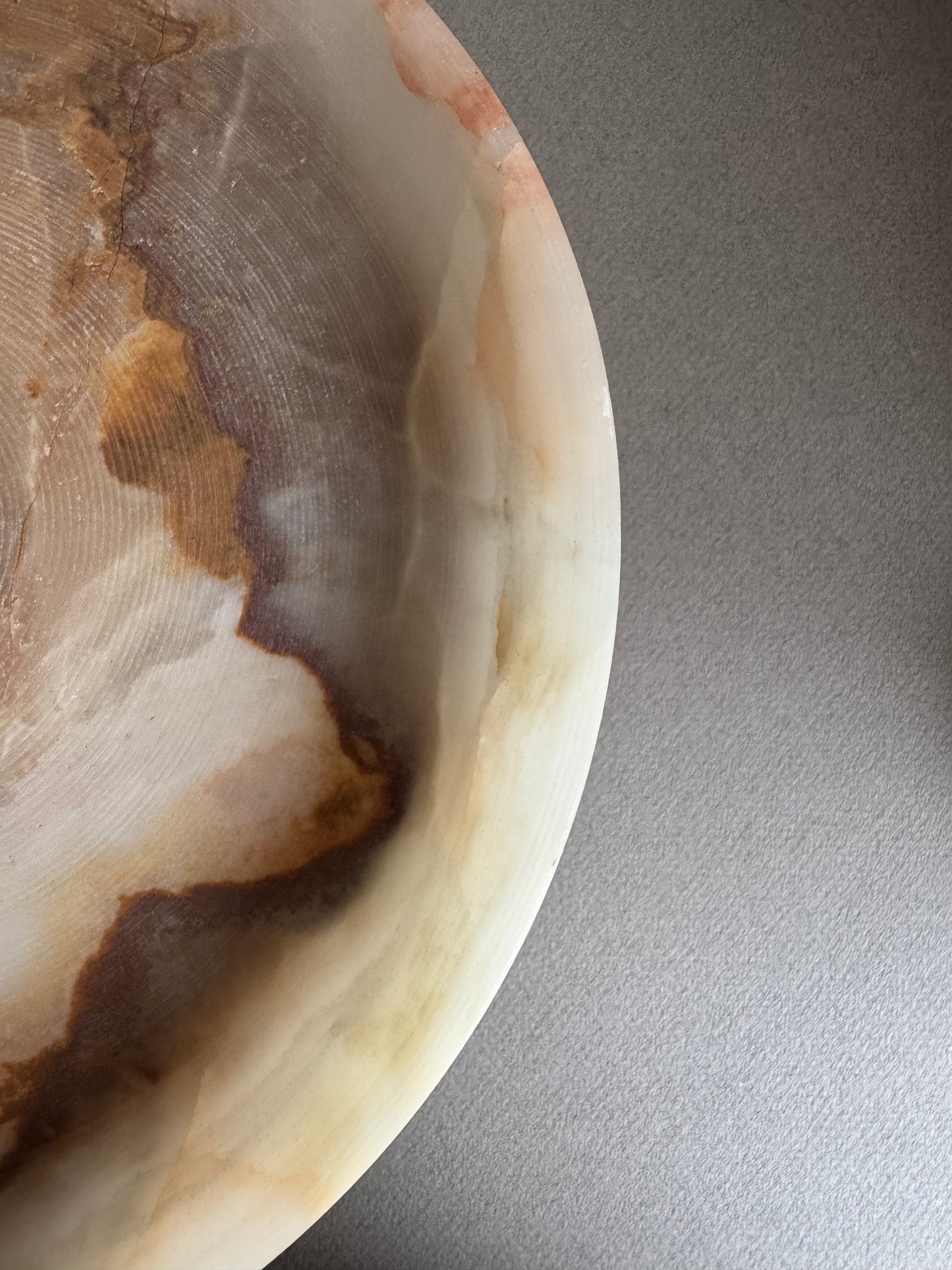 Sculptural onyx bowl in sage and gray tones resting on a clean tabletop, ready for use or display

