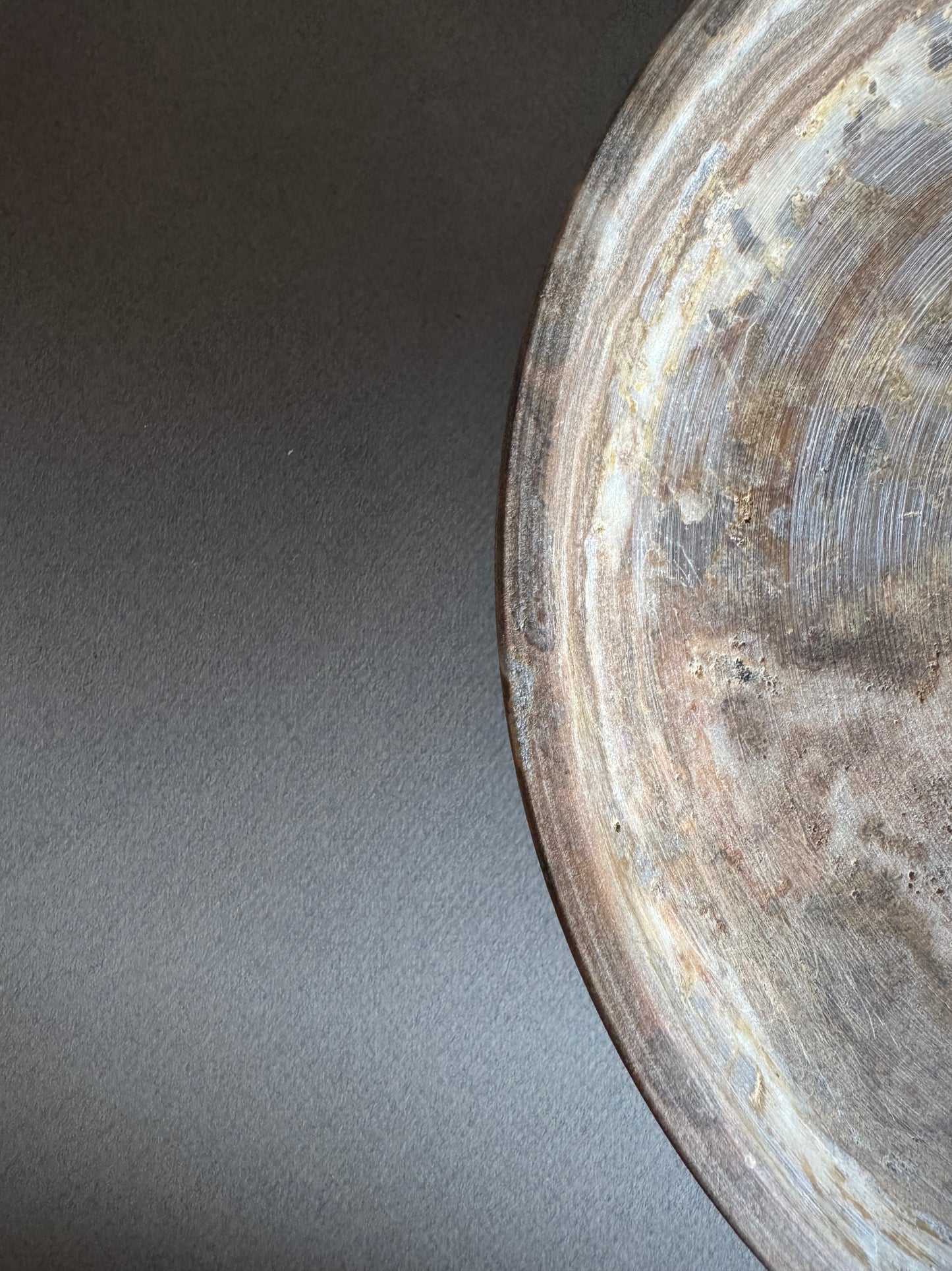 Close-up of rim and inner surface of onyx bowl showing layered walnut and sand veining

