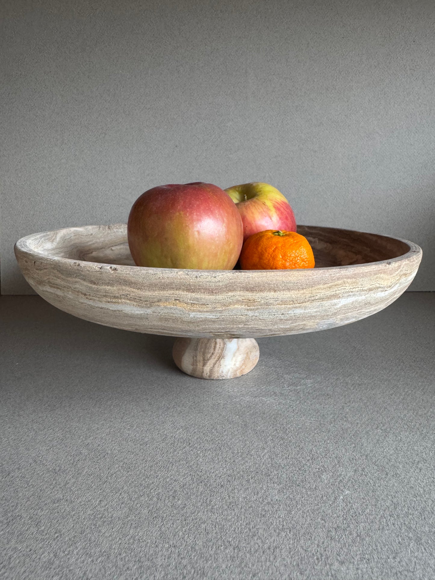 Back view of smoky-toned onyx bowl showing smooth base and carved pedestal form