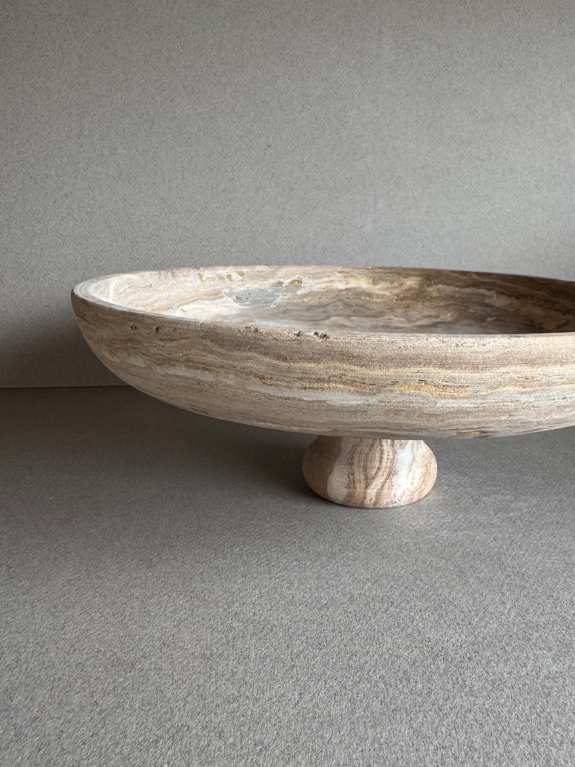Minimalist interior scene with SAÉA pedestal bowl in warm brown and taupe veining

