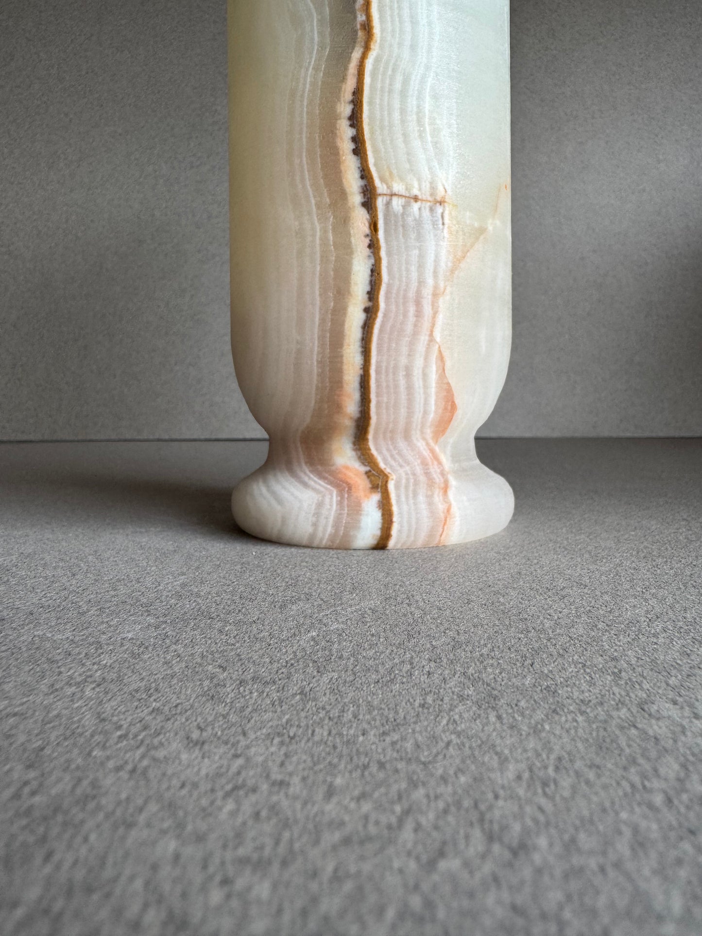Close-up of base showing distinct layered onyx texture and central vein detail.

