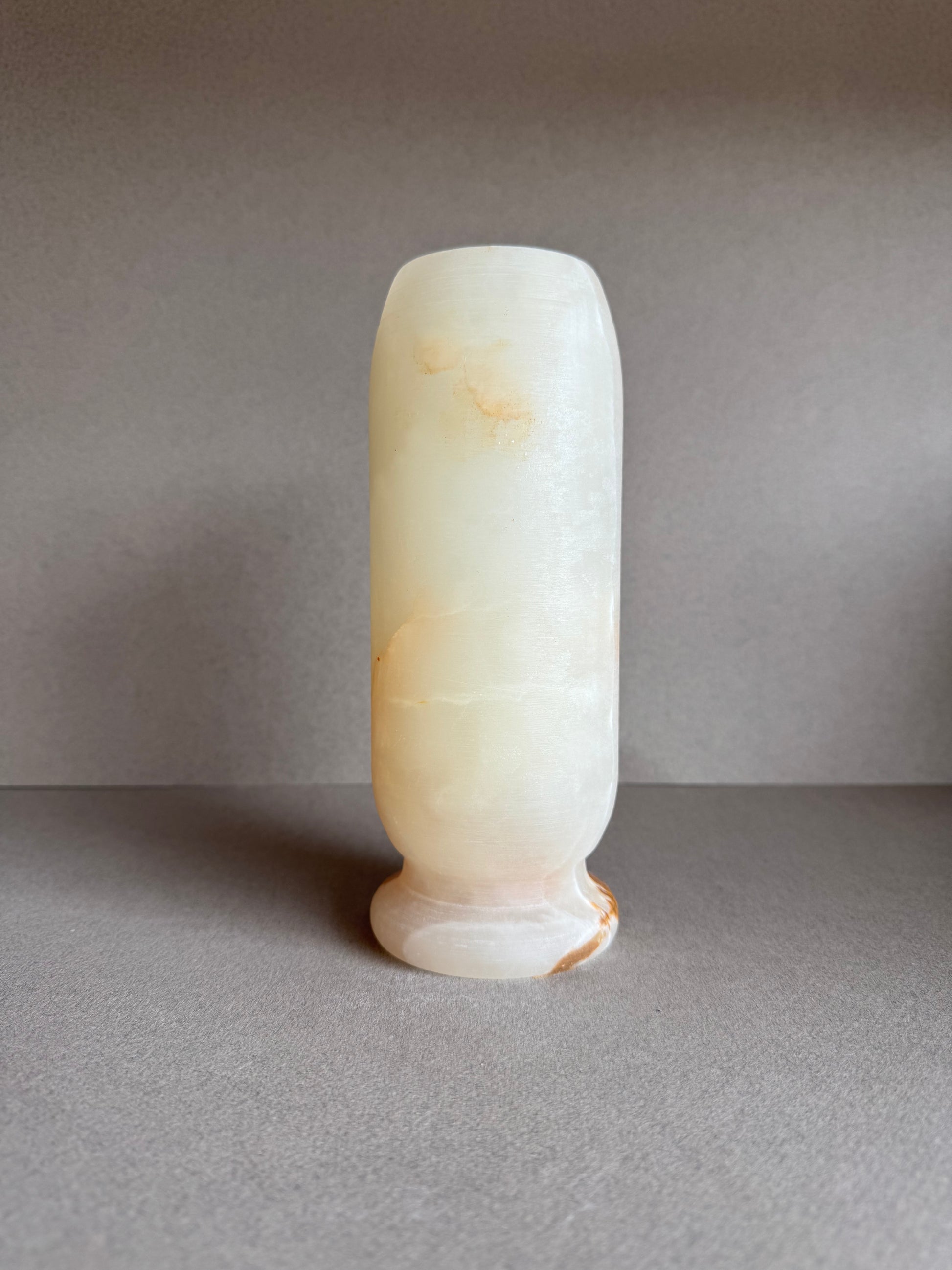 Back view of onyx vase showing gradient tones from peach to sand.

