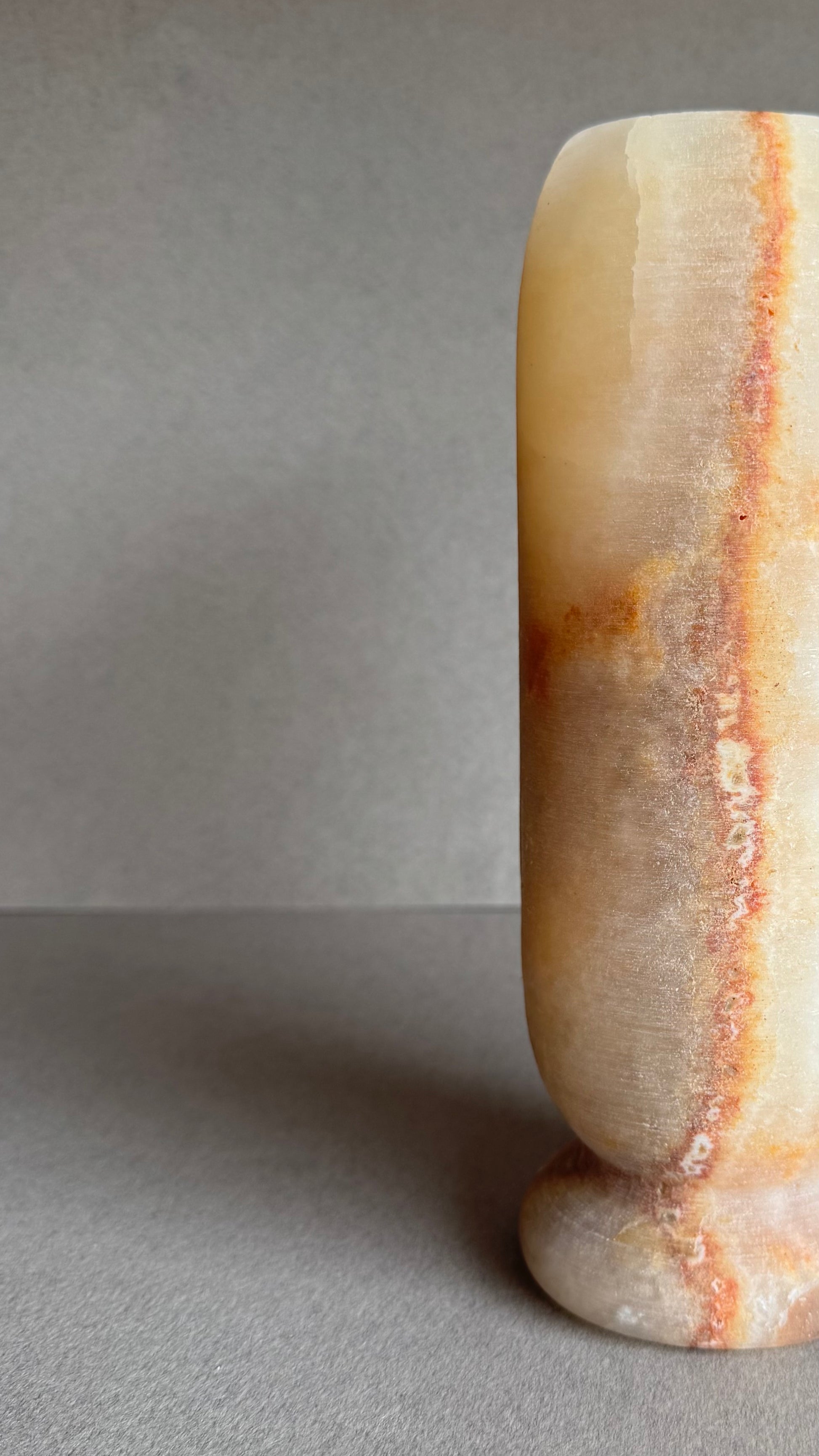Close-up angled view showing layered orange and cream banding.

