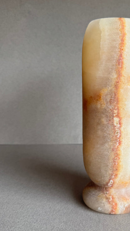 Close-up angled view showing layered orange and cream banding.

