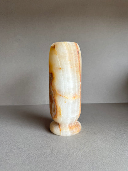 Onyx vase in soft honey and peach tones with marbled amber mineral bloom on front.

