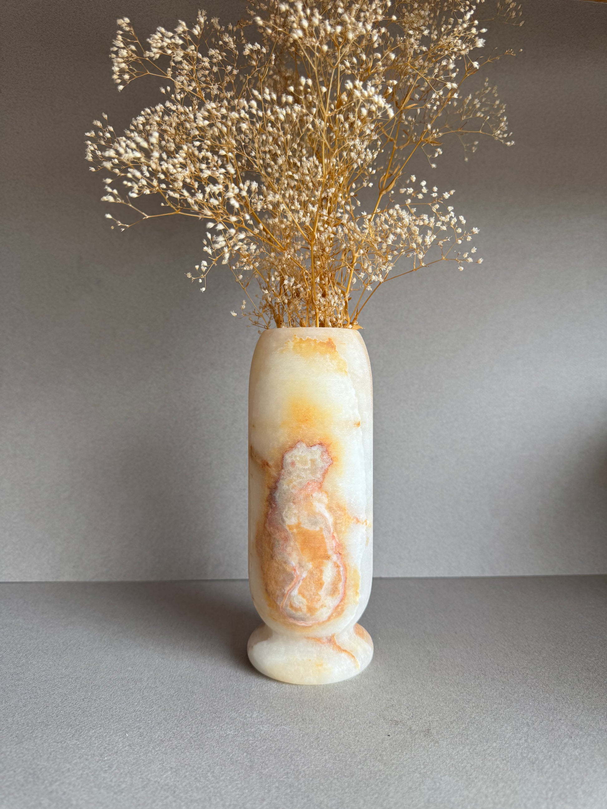 Front view of tall vase featuring warm golden hues and distinct organic patterning.

