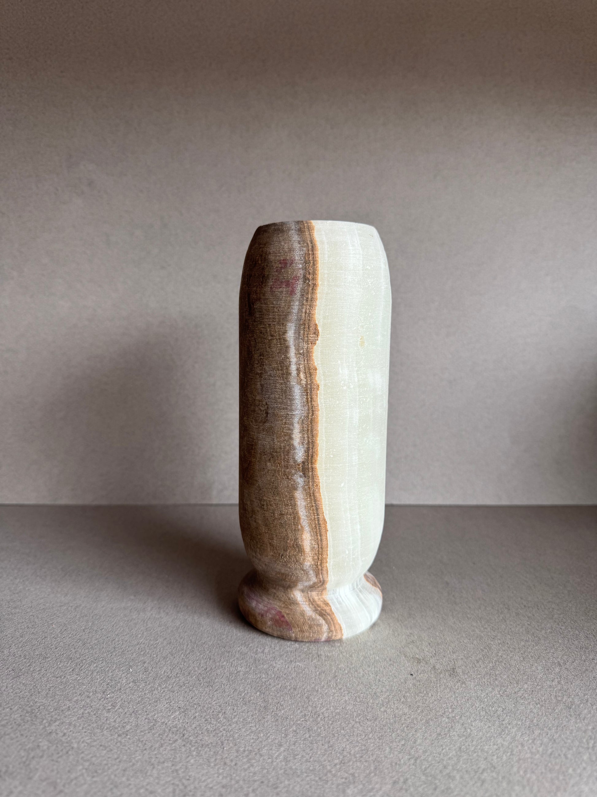 Side angle of onyx vase showing soft matte finish and organic lines in natural stone.

