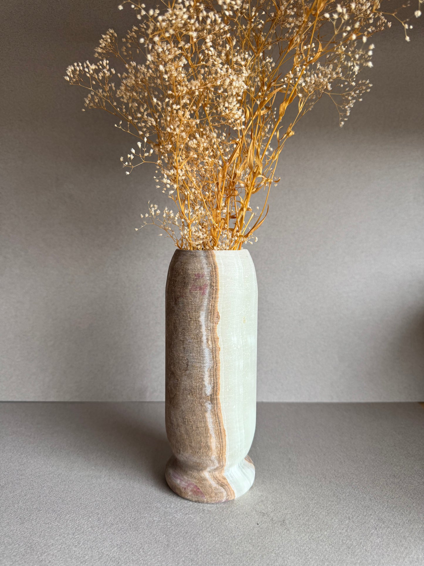 Vase styled with dried baby’s breath florals, standing tall against a neutral backdrop.

