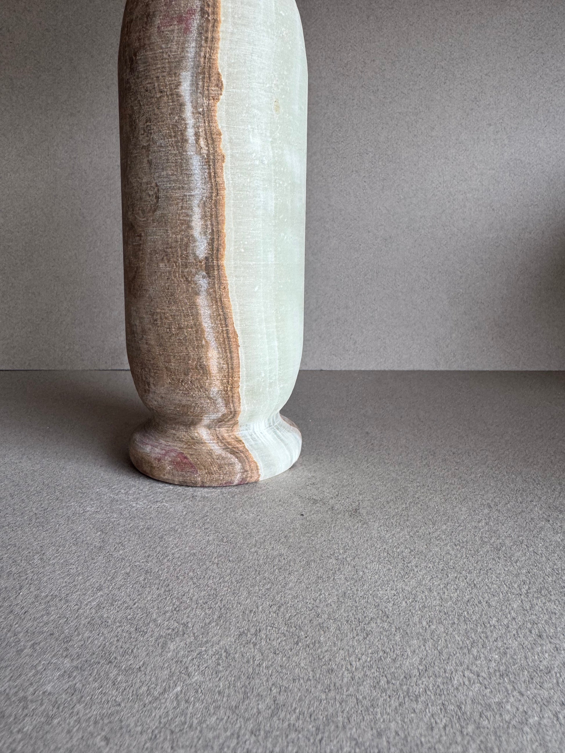 Close-up of the base and midsection, showing layered veining and polished edge.

