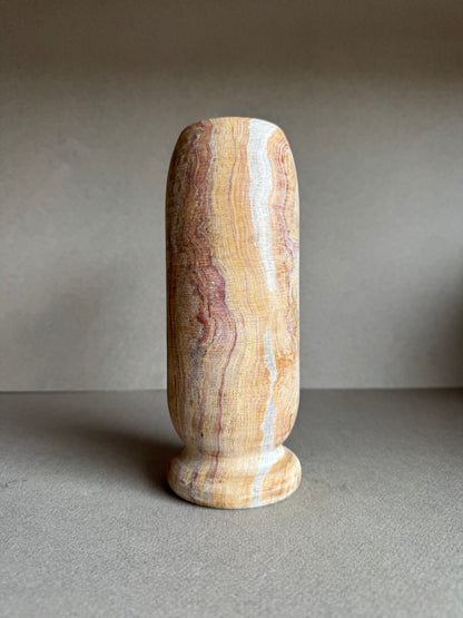Side view showing warm striations of tan, pink, and white on natural stone.

