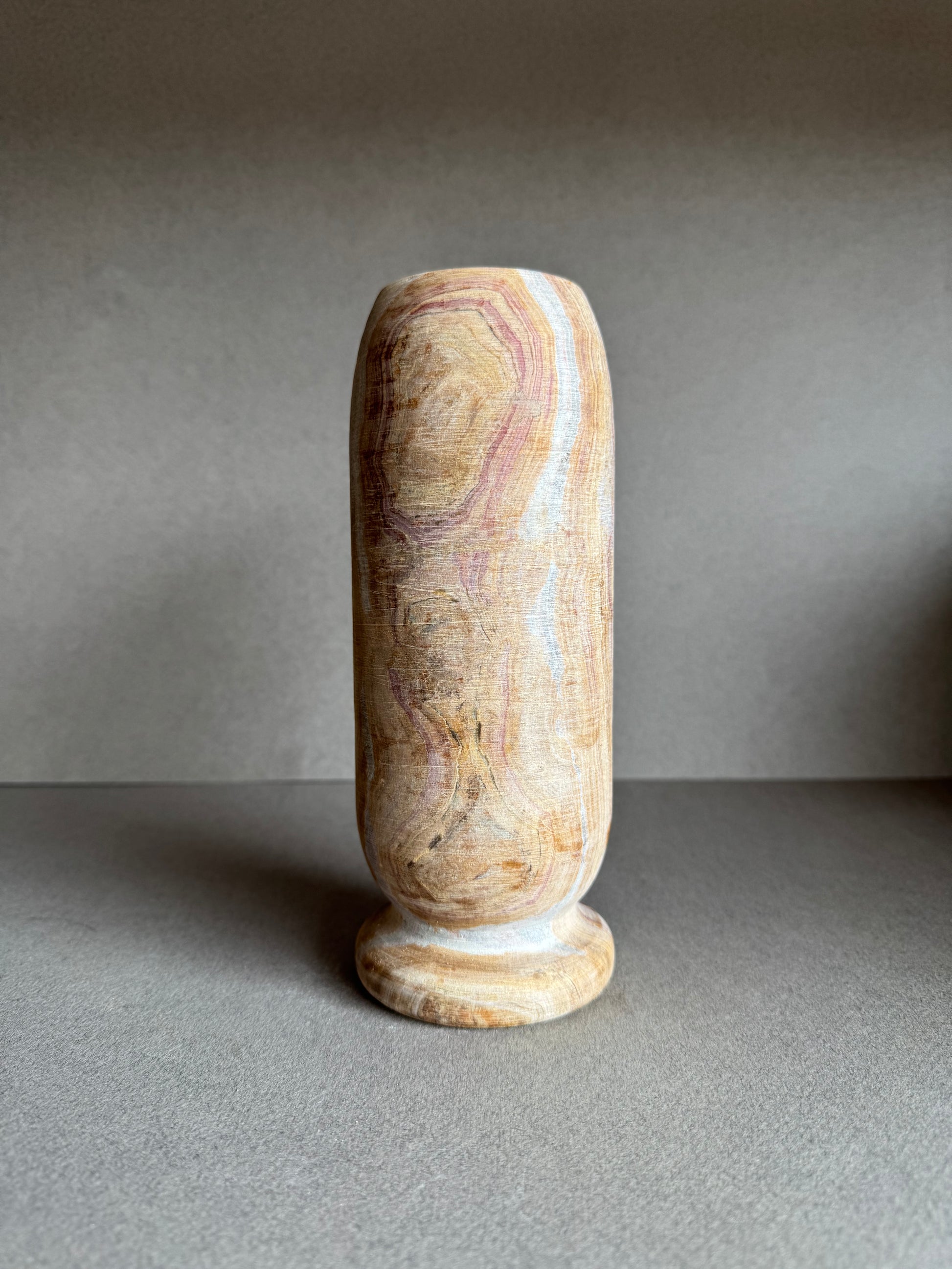 Rear profile with bold rose marbling and textured mineral surface.

