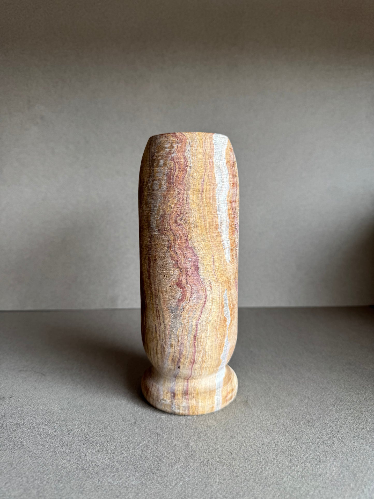 Rear profile with bold rose marbling and textured mineral surface.

