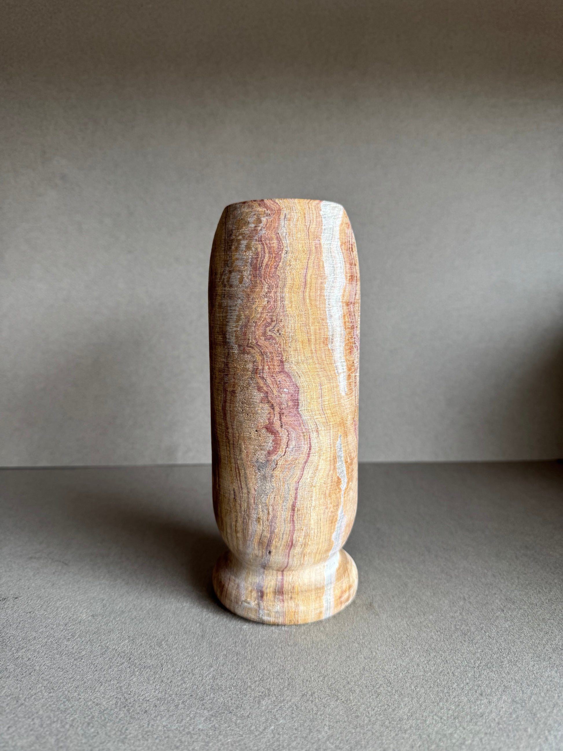 Rear profile with bold rose marbling and textured mineral surface.

