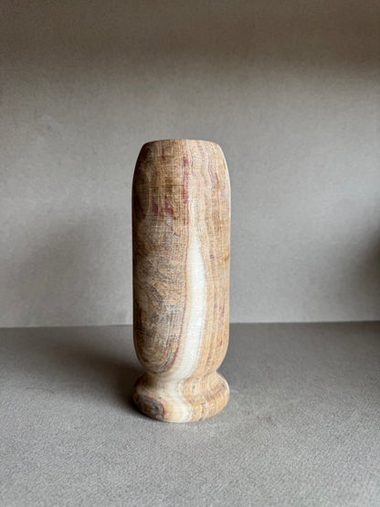 Side view of cylindrical vase highlighting vertical bands of cream, pink, and brown.

