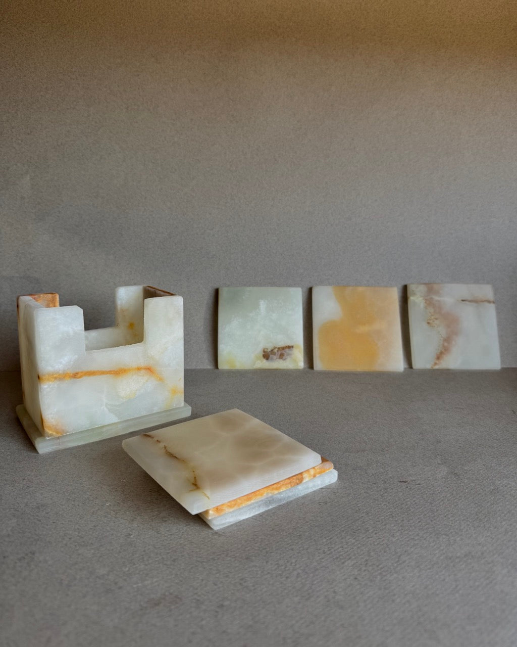 Coaster set with holder and coasters arranged upright, displaying the variation in onyx tones

