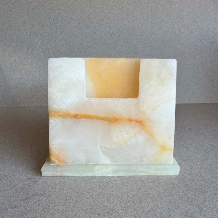 Front view of handcrafted onyx coaster holder with golden amber tones and matching square coasters

