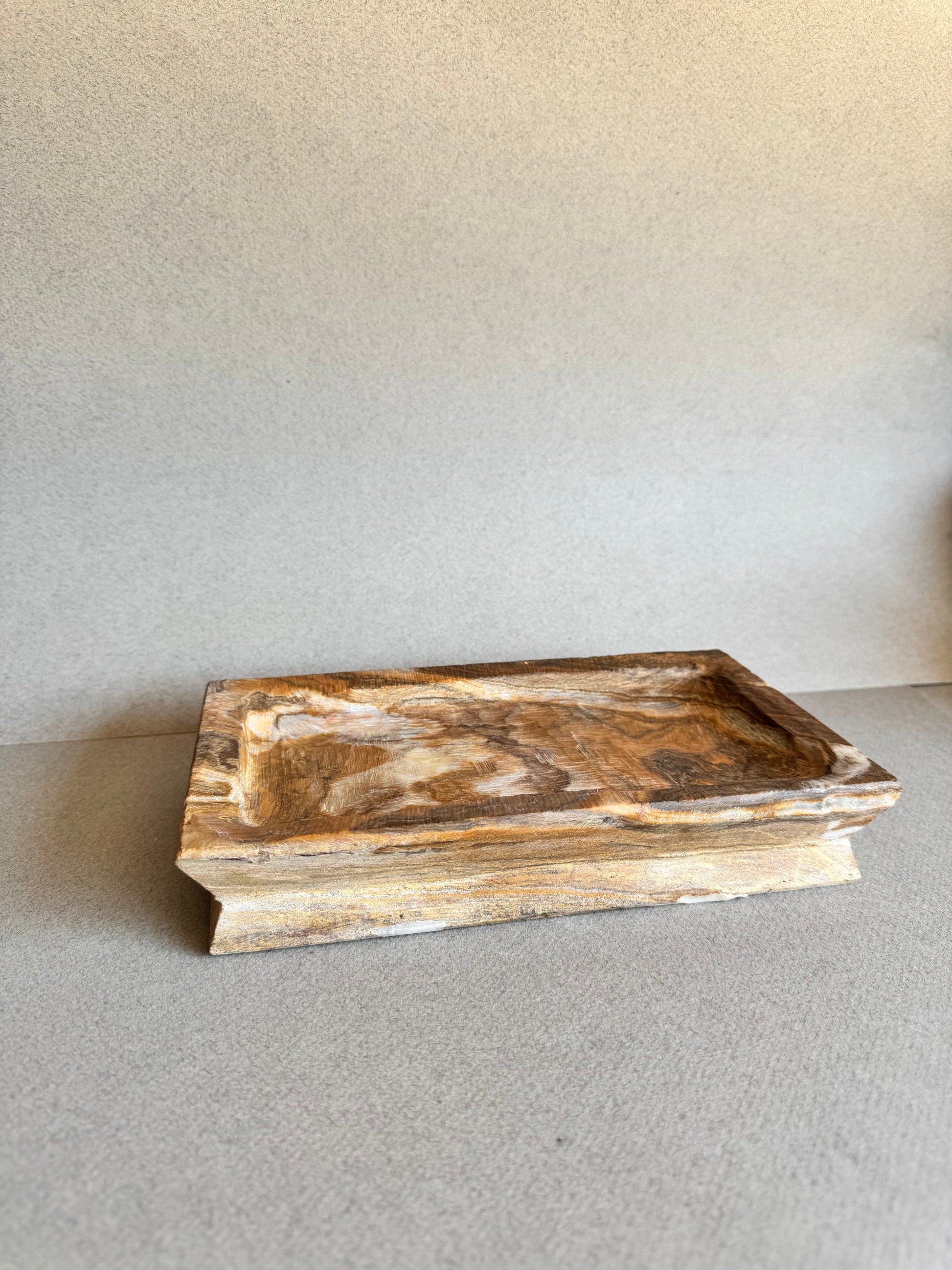 Side angle of SAÉA rectangular natural stone tray with marbled amber veining

