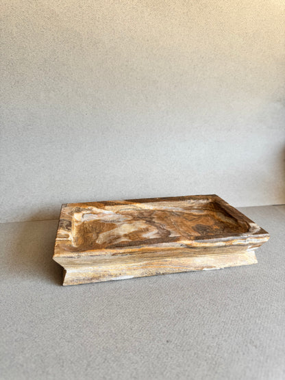Side angle of SAÉA rectangular natural stone tray with marbled amber veining

