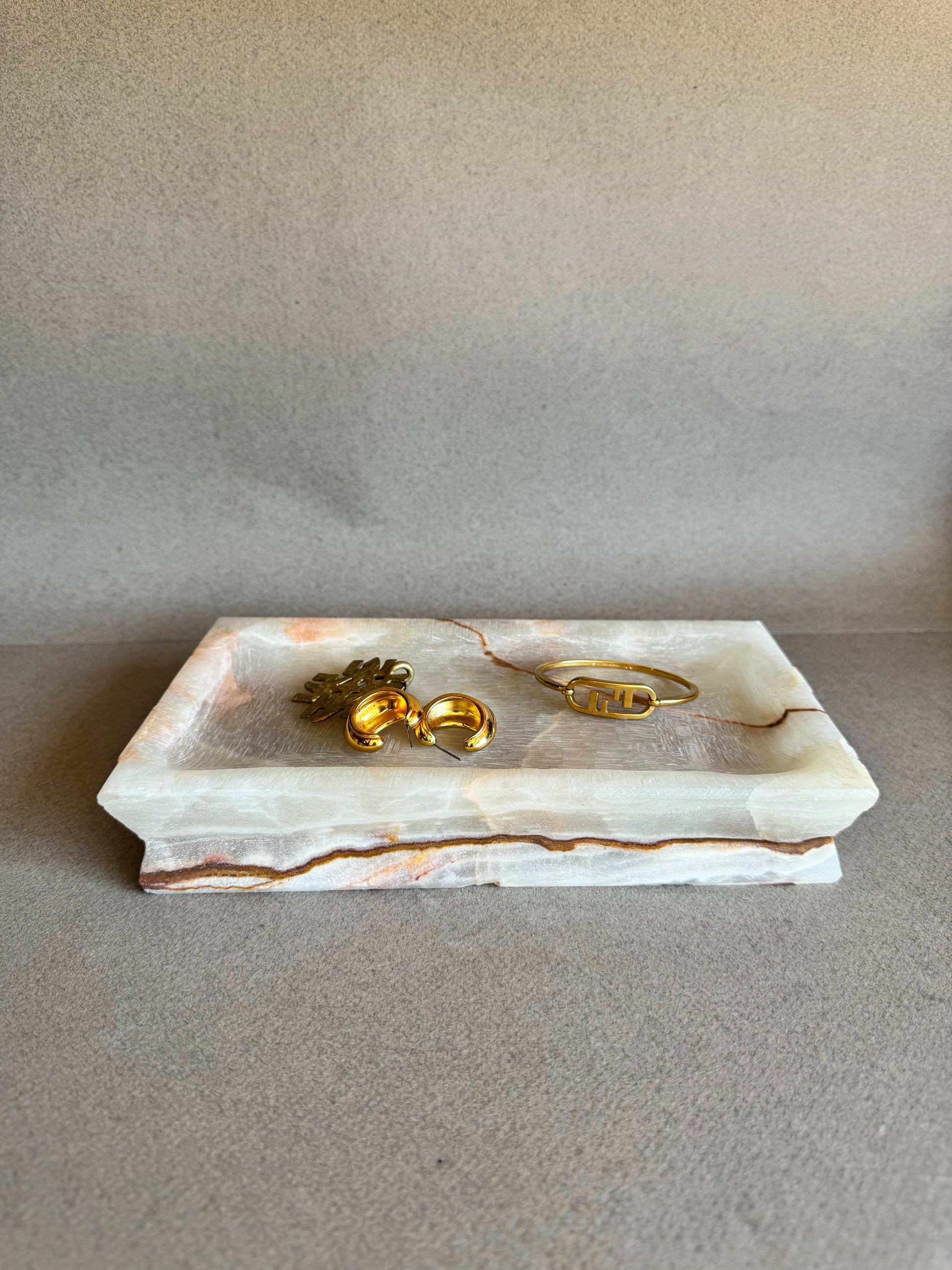 Natural stone vanity tray with warm rust, amber, and beige layers