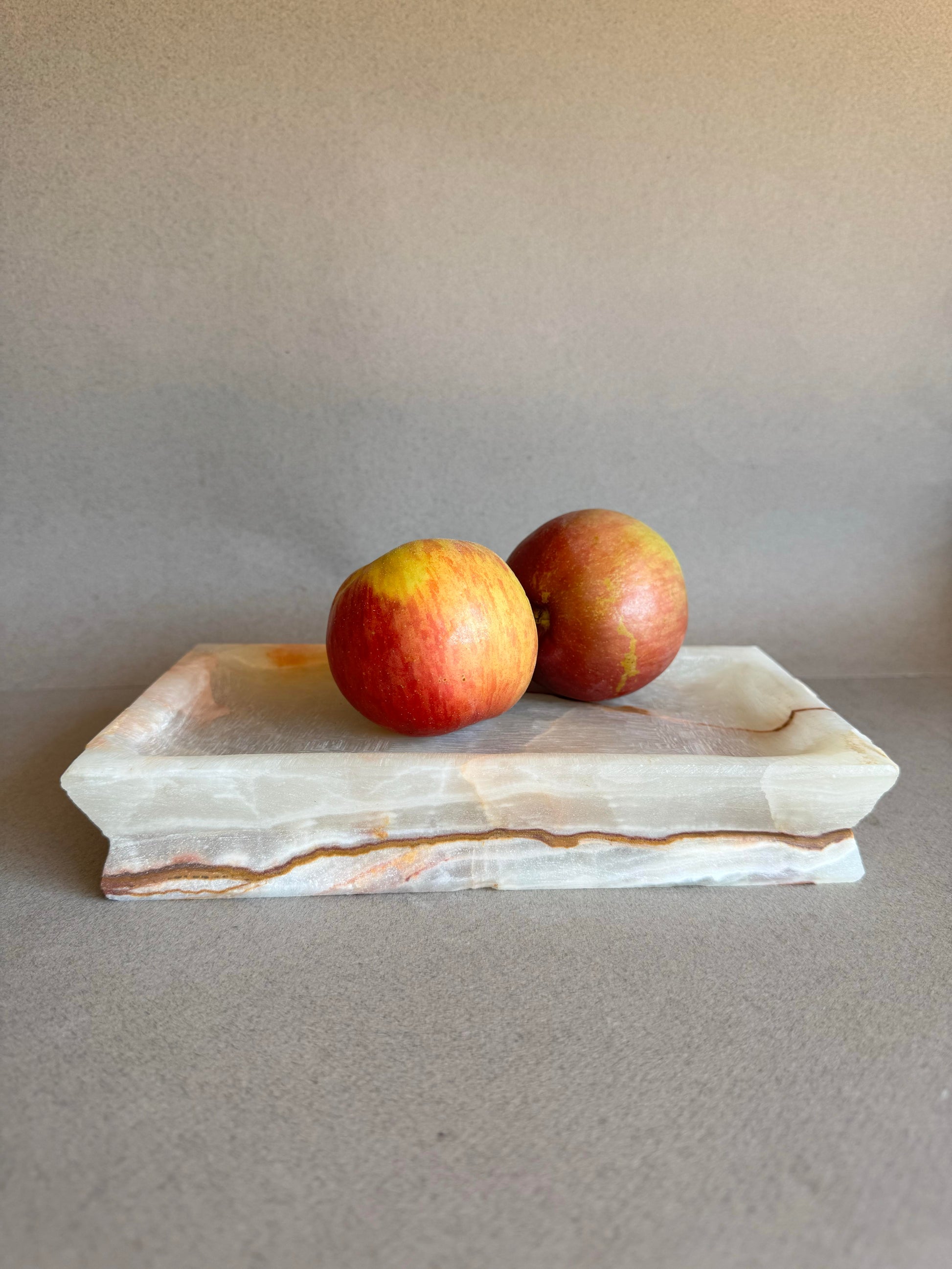 Two apples resting on hand-carved onyx catchall