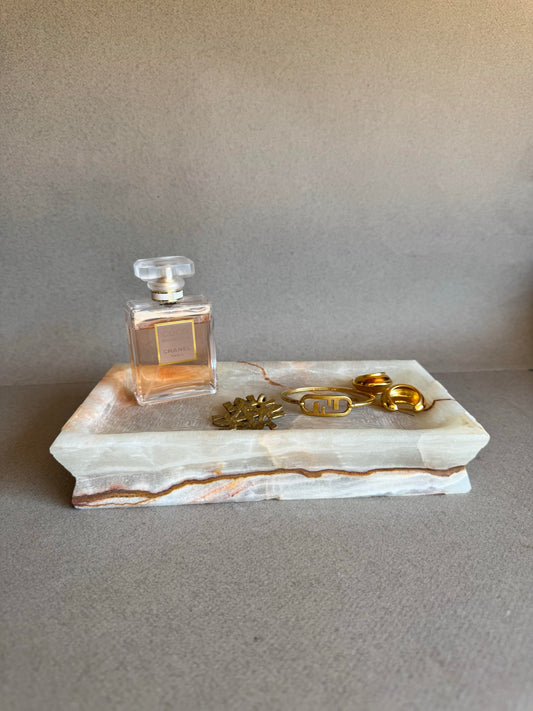 Jewelry and perfume styled on sculptural stone tray