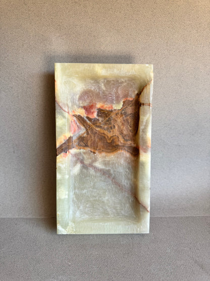 Top-down view of catchall tray showcasing a dramatic onyx pattern in rust and red

