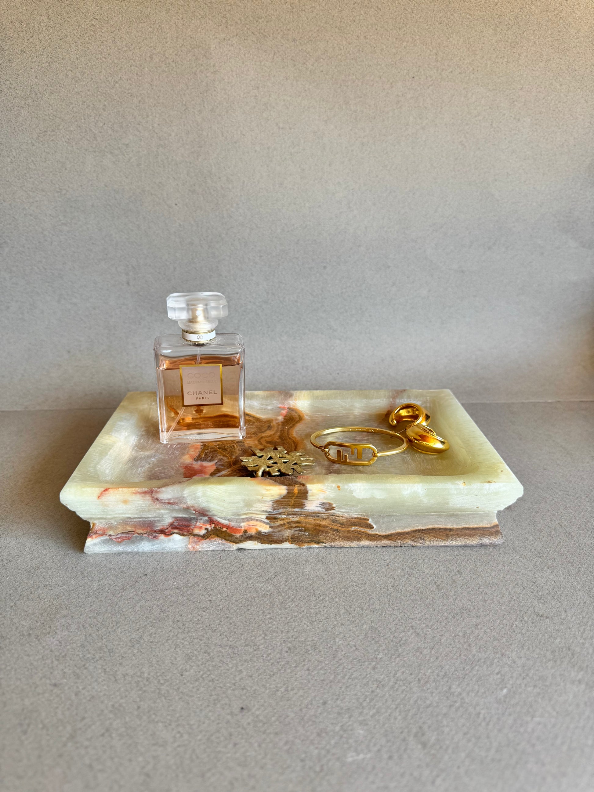 Vanity tray in onyx styled with perfume and gold jewelry, showing its multi-use versatility

