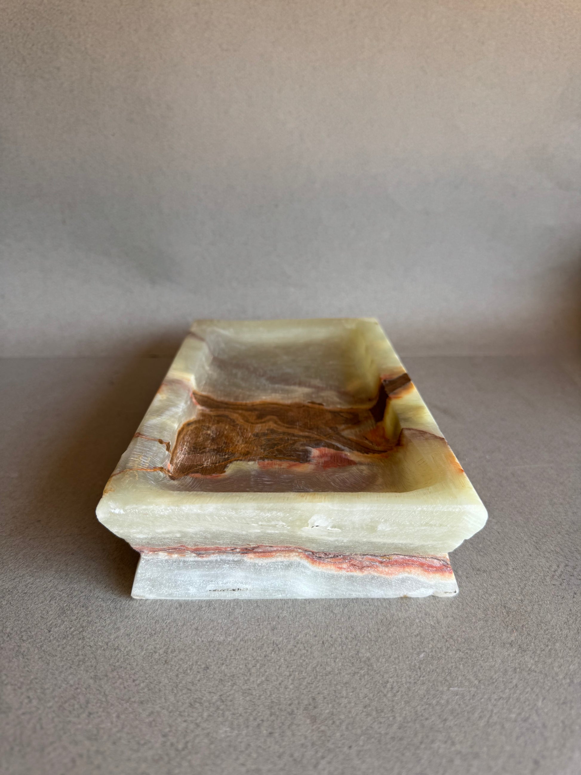 Stepped-edge onyx catchall tray in marbled cream and burnt red with deep carved basin

