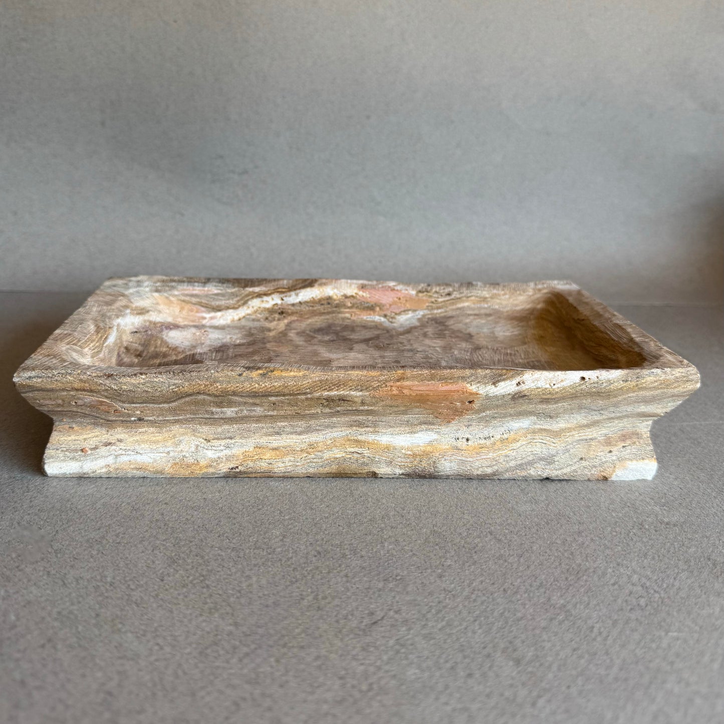 Rectangular onyx tray in taupe and rose tones on neutral background