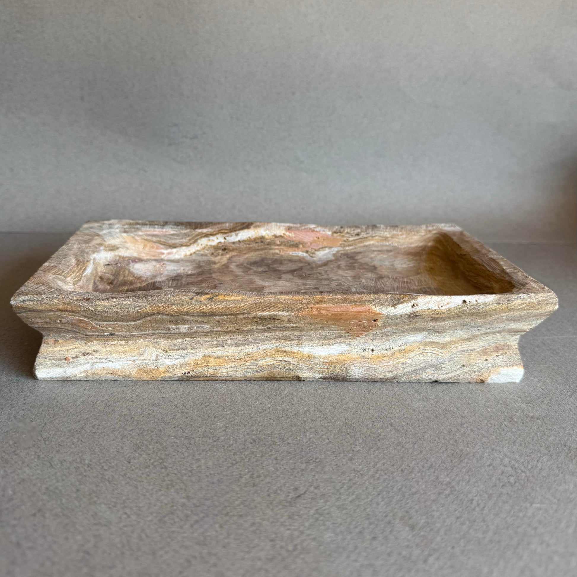 Rectangular onyx tray in taupe and rose tones on neutral background