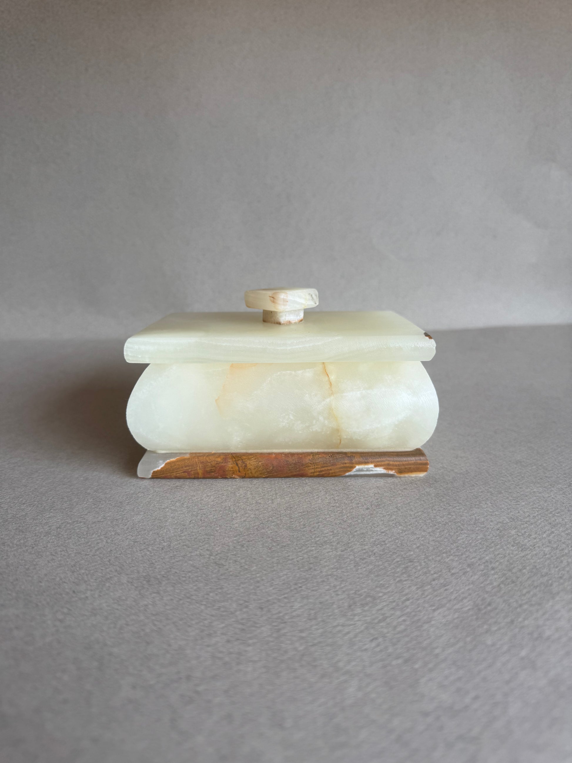 Minimalist onyx container with soft matte finish and earth-toned marbling

