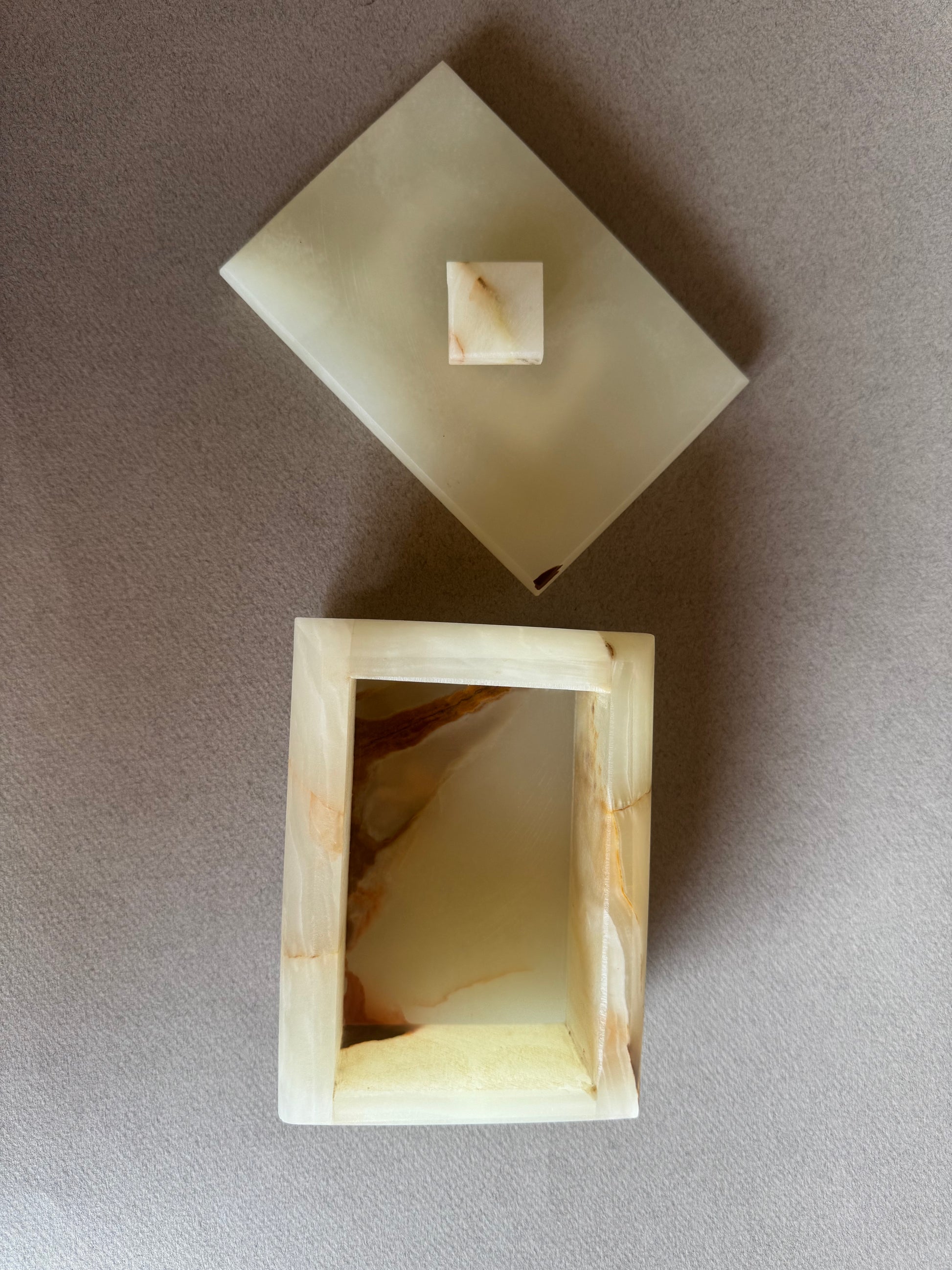 Top view of lidded onyx jewelry box showing soft veining and curved shape

