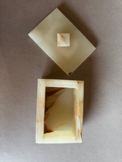 Top view of lidded onyx jewelry box showing soft veining and curved shape

