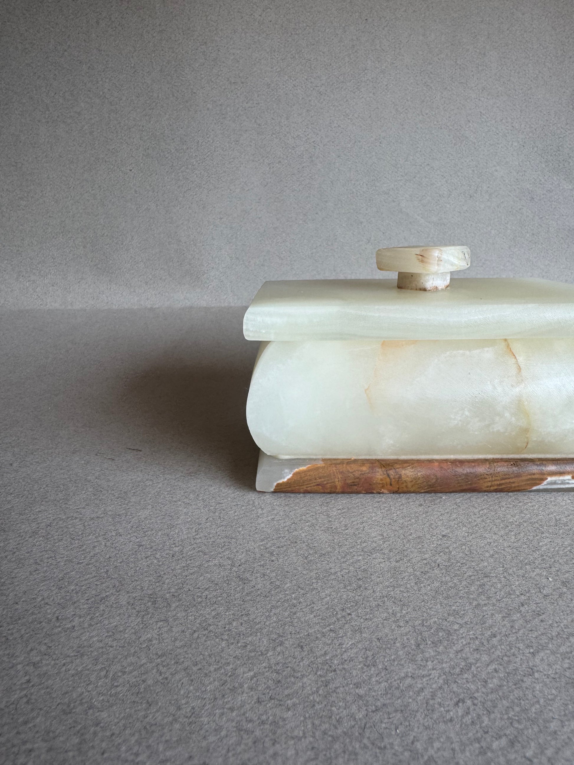 Side view of natural onyx box glowing with translucent veining in sunlight

