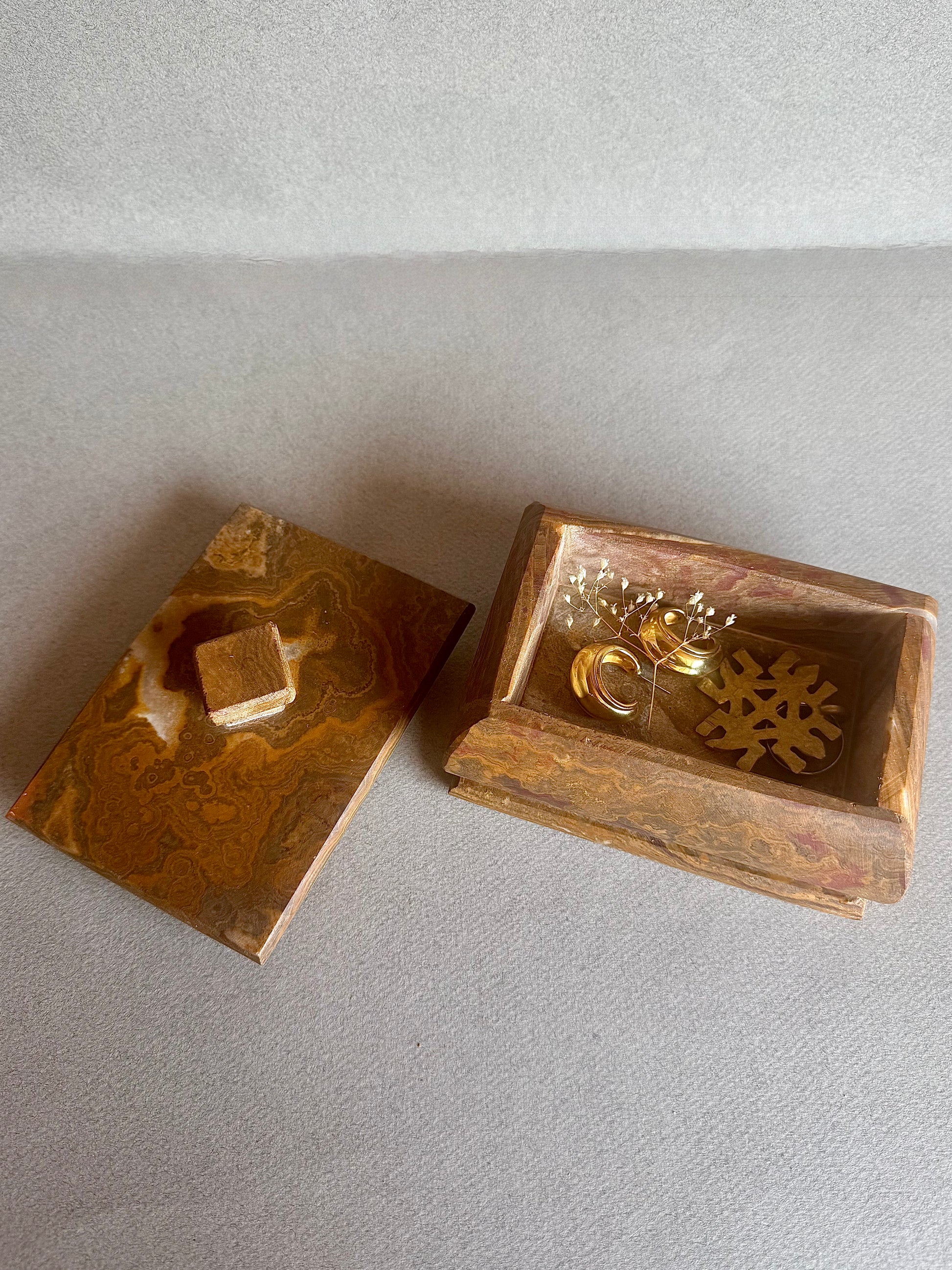 Front-facing sculptural stone jewelry box with curved form and matching lid

