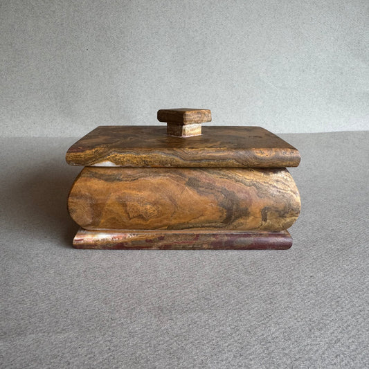 Front view of rust onyx keepsake box with lid, carved from natural walnut and ochre-toned stone

