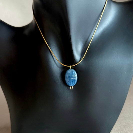 Necklace with a blue kyanite gemstone pendant on a black mannequin bust.