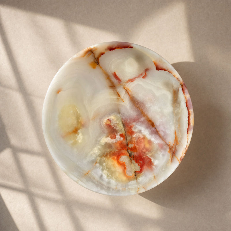 Marbled pink onyx bowl bar on a neutral background