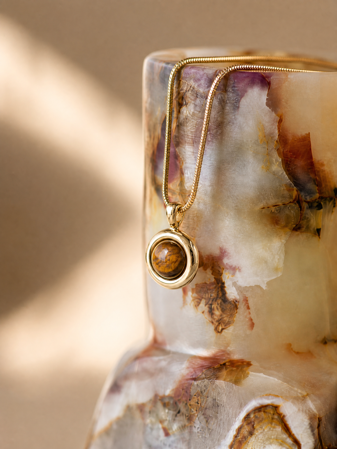 Macro close-up of SAÉA natural stone beaded jewelry showing varied color, banding, and natural surface texture across the beads